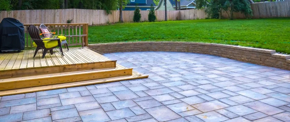 Patio and retaining wall in Wendell, NC, beside a green lawn.