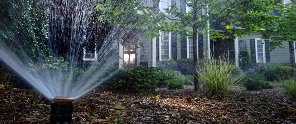 Sprinklers in a landscape in Clayton, NC, spraying water.